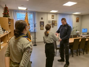 zdjęcie przedstawia harcerzy przekazujących komendantowi Betlejemskie Światełko Pokoju w gabinecie szefa rudzkiej Policji