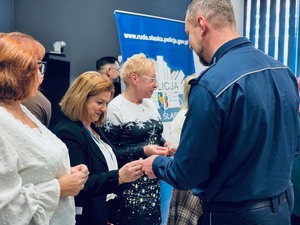 zdjęcie - komendant łamie się opłatkiem z pracownikami Policji