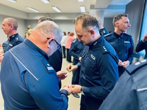 zdjęcie - policjanci składają sobie życzenia łamiąc się opłatkiem