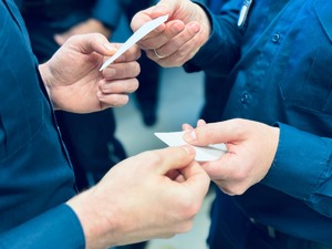 zdjęcie - ręce policjantów łamiących się opłatkiem