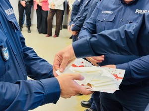 zdjęcie - policjant rozdaje opłatki wyłożone na tacy