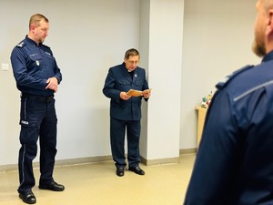 zdjęcie - kapelan Policji czyta fragment z Pisma Świętego, obok stoi komendant