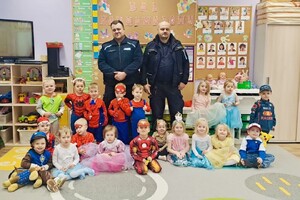 Zdjęcie przedstawia dzielnicowych pozujących do zdjęcia z przedszkolakami
