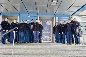 Grupa uczniów wraz z policjantem pozują do zdjęcia