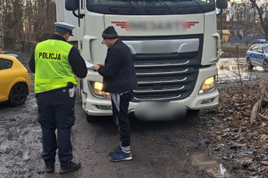 Policjant ruchu drogowego w trakcie kontroli pojazdu ciężarowego