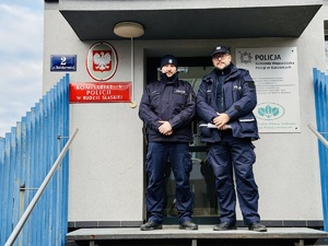 Policjanci pozują do zdjęcia przed wejściem do komisariatu
