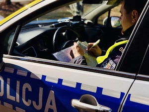 Policjant w radiowozie w trakcie czynności służbowych