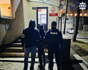 Zatrzymany mężczyzna w trakcie doprowadzenia przez policjantów