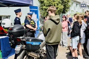 Młodzież przy punkcie profilaktycznym, rozmawia z policjantami