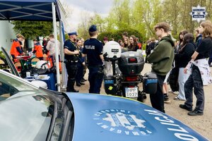 Młodzież przy punkcie profilaktycznym, rozmawia z policjantami