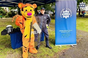 Policjant z maskotka pozują do zdjęcia