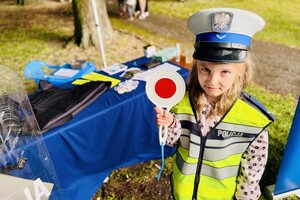 Dziewczynka przebrana za policjantkę ruchu drogowego pozuje do zdjęcia