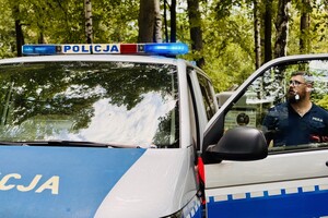 Policjant włącza sygnały świetlne w radiowozie