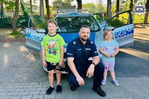 Policjant pozuje do zdjęcia z dziećmi