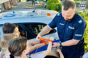 Policjant rozdaje odblaski dzieciom
