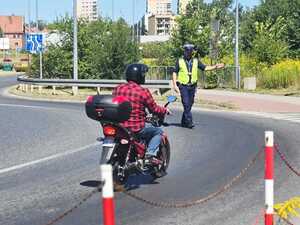 policjant przeprowadza kontrolę drogową motocyklisty