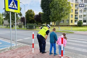 Policjanci ruchu drogowego ćwiczą z dziećmi przechodzenie przez jezdnię