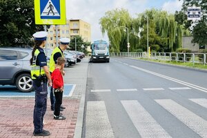 Policjanci ruchu drogowego ćwiczą z dziećmi przechodzenie przez jezdnię
