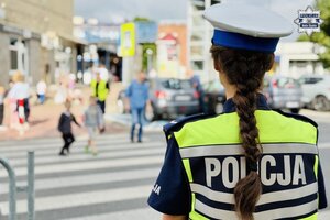 Policjanci ruchu drogowego ćwiczą z dziećmi przechodzenie przez jezdnię