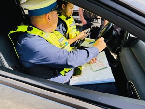 policjanci w radiowozie wypisujący dokumentację po kontroli pojazdu