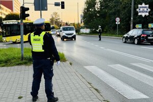 Policjant ruchu drogowego stoi przy przejściu dla pieszych