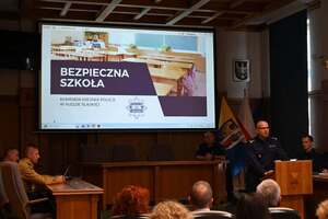 Komendant Policji w trakcie przemówienia, w tle prezentacja
